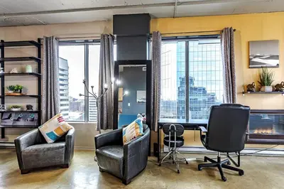 an office with two chairs and a desk and windows at Industrial-Style Cityscape 1 Bedroom Loft in Edmonton