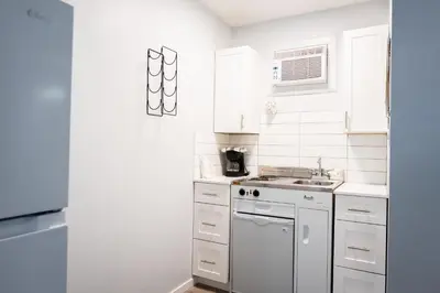 a white kitchen with a stove and a sink at Poplars Motel on the lake in Osoyoos