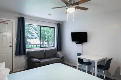 a room with a bed and a couch and a table at Poplars Motel on the lake in Osoyoos