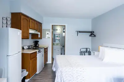 a small kitchen with a bed in a room at Poplars Motel on the lake in Osoyoos