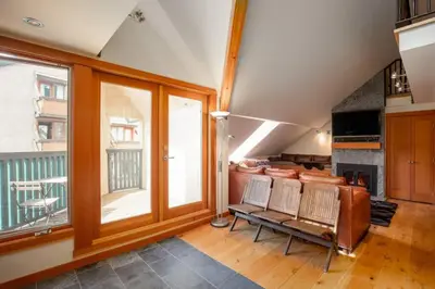a living room with chairs and a large window at The Ikon Lofted Studio with King Bed and Patio in Whistler