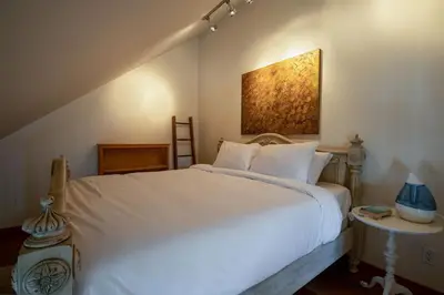 a bedroom with a white bed and a painting on the wall at The Ikon Lofted Studio with King Bed and Patio in Whistler
