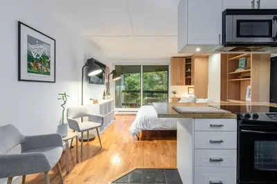 a kitchen and living room with a bed in a room at Casa Creekside - Walk to Gondola, Shops, lakes! in Whistler
