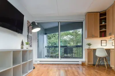 a living room with a large window and a chair at Casa Creekside - Walk to Gondola, Shops, lakes! in Whistler