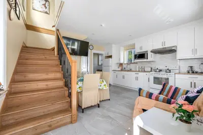 a kitchen and a living room with a stairway at Three bedrooms new laneway house near public transit & FIFA training site in Vancouver