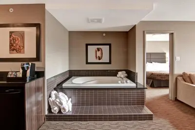 a large bath tub in a room with a bed at Canalta Lac La Biche in Lac La Biche
