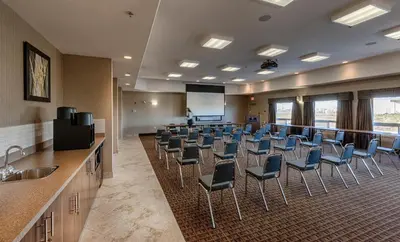 a conference room with chairs and a projection screen at Canalta Lac La Biche in Lac La Biche