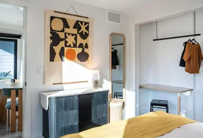 a bedroom with a bed and a mirror at Snowed Inn - Stunning 3 Bedroom Condo in Revelstoke