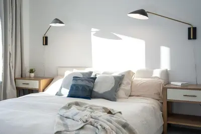 a bedroom with a bed with two lamps on it at Snowed Inn - Stunning 3 Bedroom Condo in Revelstoke