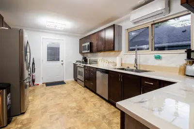 a large kitchen with wooden cabinets and a refrigerator at NorthVAN nature living home in North Vancouver