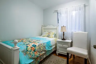 a bedroom with a bed and a chair and a window at NorthVAN nature living home in North Vancouver