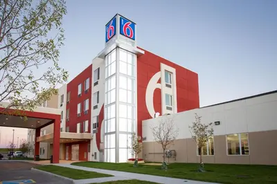 a building with a clock tower on the side of it at Motel 6 Airdrie in Airdrie