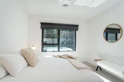 a white room with a bed and a mirror at Mountainview Escape by Revelstoke Vacations in Revelstoke