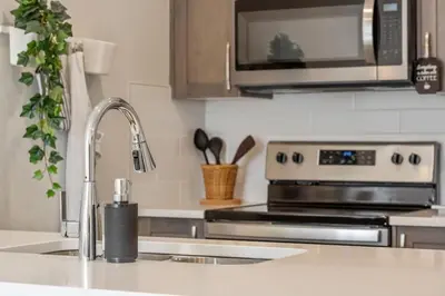 a kitchen with a sink and a microwave at Private Town Home with Free Banff Access, Netflix, King Bed, Fully Equipped Kitchen, Sleeps 4 in Calgary