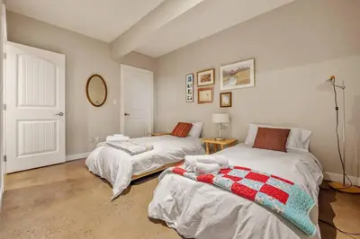 a bedroom with two beds and a table at Escape to the Rockies but near Calgary Includes Free Parking and Banff Entry in Calgary