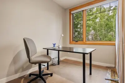 a desk and a chair in a room with a window at Escape to the Rockies but near Calgary Includes Free Parking and Banff Entry in Calgary