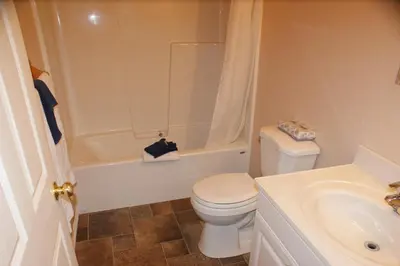 a bathroom with a toilet and a tub and a sink at Elks Motel in Keremeos