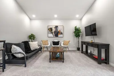 a living room with a couch and a tv at Top Rated Luxury House with Central AC, Double Garage Parking, 2 Kitchens, 5 Bedrooms & More! in Balzac