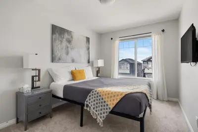 a bedroom with a bed and a large window at Top Rated Luxury House with Central AC, Double Garage Parking, 2 Kitchens, 5 Bedrooms & More! in Balzac