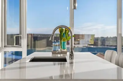 a kitchen counter with a sink and a window at Luxury Apartment on the 9th Floor near Stampede, Complimentary Wine, 2 Car UG Parking in Calgary