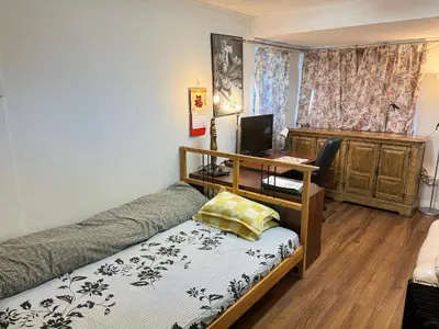 a bedroom with a bed and a desk with a computer at Friendly and cozy home with separate entrance No Pets Allowed in Burnaby