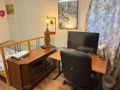 a room with a desk with a computer and a chair at Friendly and cozy home with separate entrance No Pets Allowed in Burnaby