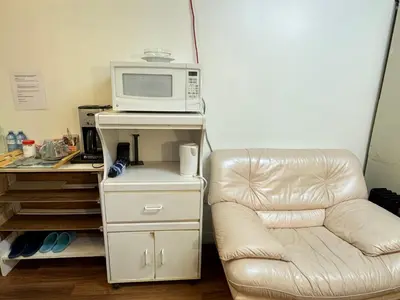 a microwave sitting on a stand next to a couch at Friendly and cozy home with separate entrance No Pets Allowed in Burnaby