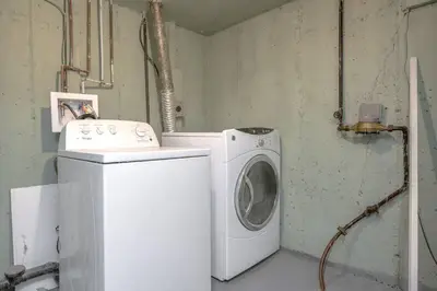 a washing machine and a washer in a room at Forth Street 2Bedroom Suite in Calgary