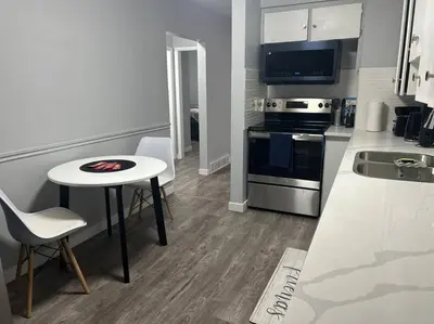 a small kitchen with a table and a stove at Cute Highland Park Upper B Unit in Calgary