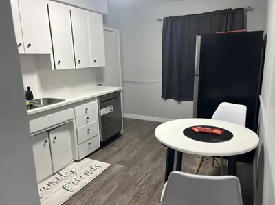 a kitchen with a small table and a black refrigerator at Cute Highland Park Upper B Unit in Calgary