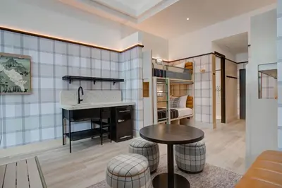 a kitchen and living room with a sink and a table at Moxy Banff in Banff