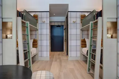 a hallway with bunk beds with a blue door at Moxy Banff in Banff