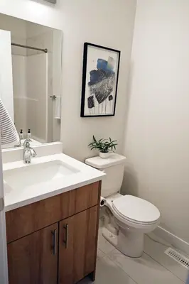 a bathroom with a white toilet and a sink at Downtown 3 Queen Beds, AC, Double Garage, Disney in Edmonton