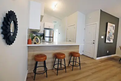 a kitchen with two stools and a counter in a room at Downtown 3 Queen Beds, AC, Double Garage, Disney in Edmonton