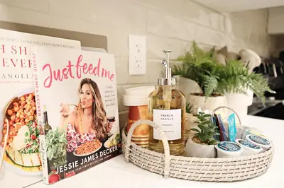 a shelf with a book and a basket of cosmetics at Downtown Suite King Beds,Long Stays,Disney+ in Edmonton