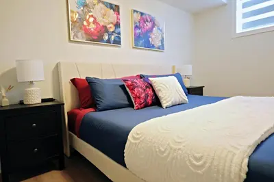 a bedroom with a bed with colorful pillows on it at Downtown Suite King Beds,Long Stays,Disney+ in Edmonton