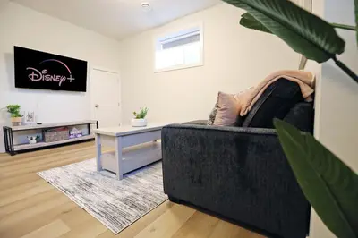 a living room with a black couch and a table at Downtown 5 Bedroom, AC, Rogers, Commonwealth, EXPO in Edmonton