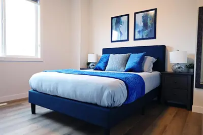a blue bed with blue pillows in a bedroom at Downtown 5 Bedroom, AC, Rogers, Commonwealth, EXPO in Edmonton