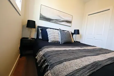 a bedroom with a large bed with blue pillows at Central 3 Queen Beds, AC, Double Garage, Disney in Edmonton