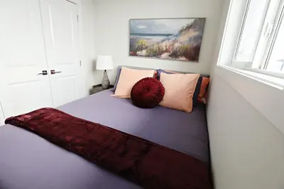 a room with a bed with pillows and a window at Central 3 Queen Beds, AC, Double Garage, Disney in Edmonton