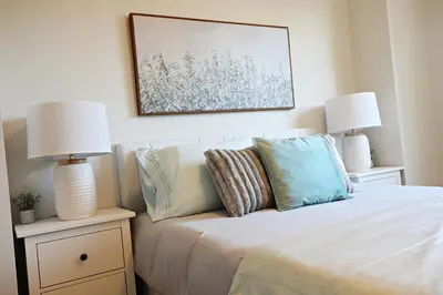 a bedroom with a bed with two lamps on it at Central 3 Queen Beds, AC, Double Garage, Disney in Edmonton