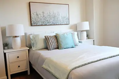 a bedroom with a bed with two night stands with lamps at Central 3 Queen Beds, AC, Double Garage, Disney in Edmonton