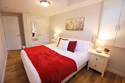a bedroom with a large bed with a red blanket at Central Suite King Beds,Long Stays,Disney+ in Edmonton