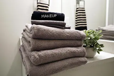 a stack of towels sitting on a shelf in a bathroom at Central Suite King Beds,Long Stays,Disney+ in Edmonton