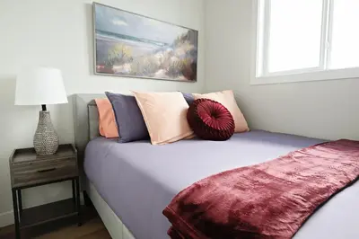 a bedroom with a bed with pillows on it at Central 5 Bedroom, AC, Rogers, Commonwealth, EXPO in Edmonton