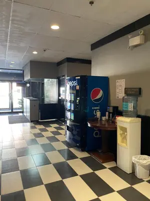 a lobby with a pepsi soda machine and a table at Nechako Valley Inn in Vanderhoof