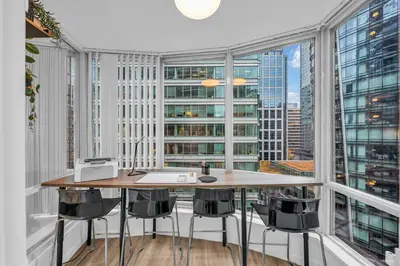 an office with a table and chairs and large windows at 1-BR Condo in Downtown Coal Harbour with Parking and City Views in Vancouver