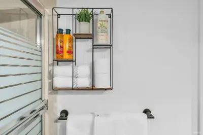 a bathroom with a rack with towels and oils at 1-BR Condo in Downtown Coal Harbour with Parking and City Views in Vancouver