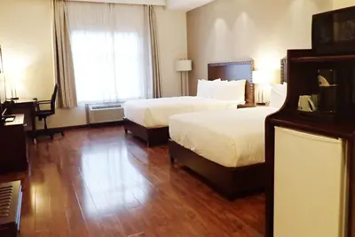 a hotel room with two beds and a desk at Days Inn & Suites by Wyndham Fort Saskatchewan in Fort Saskatchewan