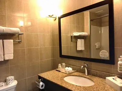 a bathroom with a sink and a mirror at Days Inn & Suites by Wyndham Fort Saskatchewan in Fort Saskatchewan